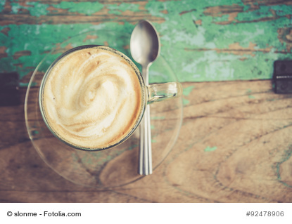 Cup of coffee on wooden table. process in retro styled